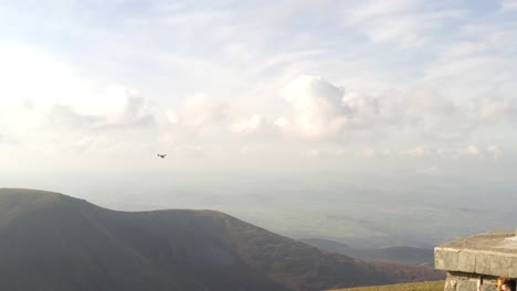 tracking pan follows airplane soaring through valley below slieve donard in northern ireland