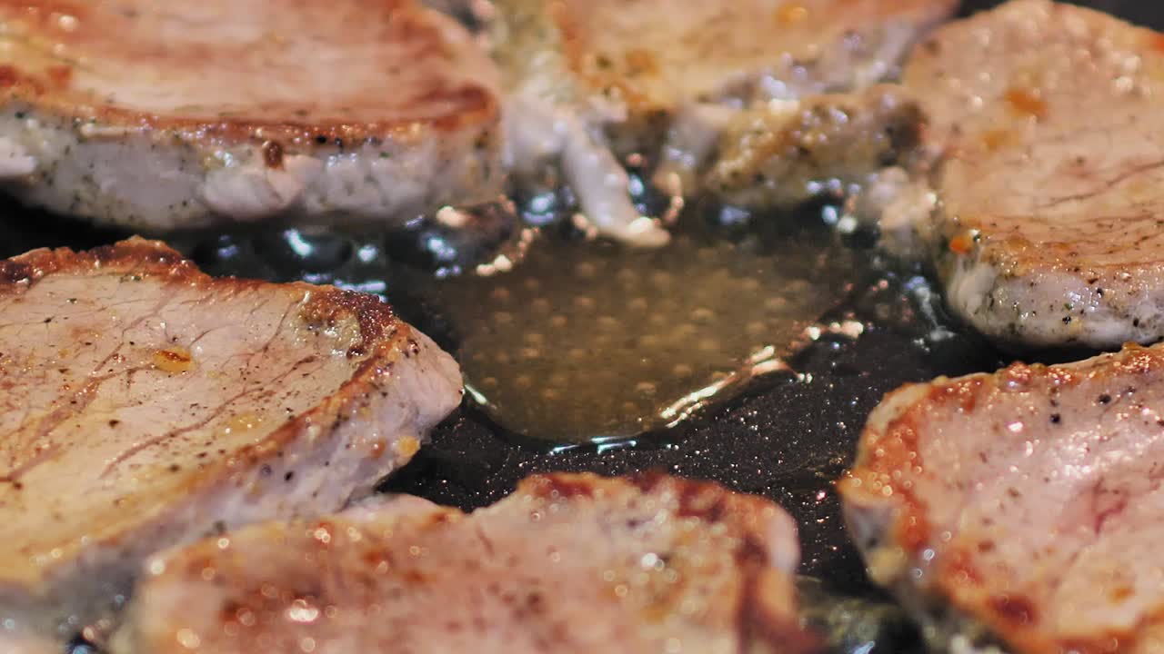 Close up of tasty pork chops cooking in a hot skillet for dinner