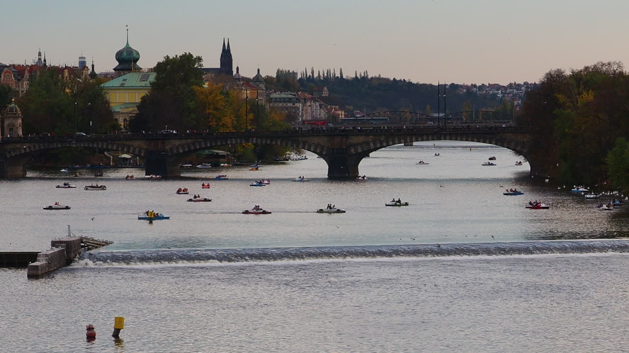 Piccole imbarcazioni turistiche e canoe navigano sul fiume Moldava a Praga, Repubblica Ceca