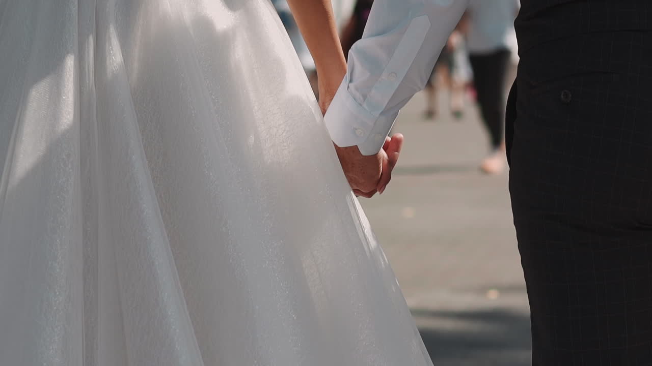 축제 의 옷 을 입은 신혼 부부 가 도시 거리 를 따라 고 있다