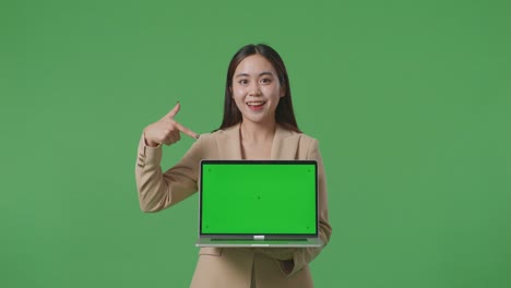 business woman presenting laptop with green screen