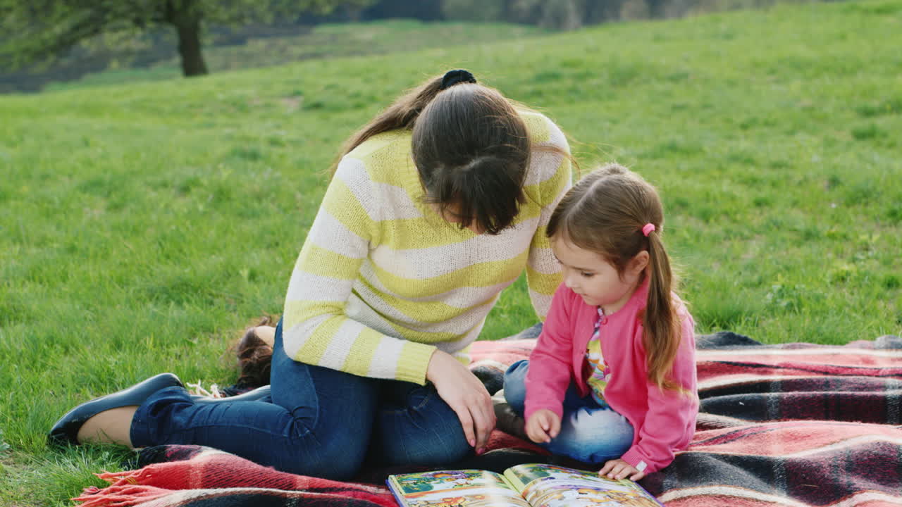una joven madre lee junto con su hija un interesante libro sobre la naturaleza