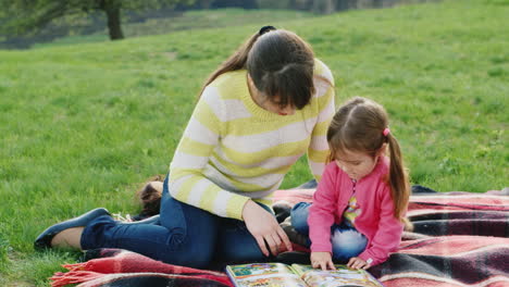 a young mother reads together with her daughter an interesting book on nature