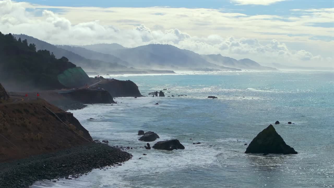 Shoreline Pacific Coastal Highway 1 DeHaven Westport Fort Bragg aerial drone California rugged Coastline blue sky surf waves crashing boulder rocks mountain side clouds sun Pacific Ocean circle right