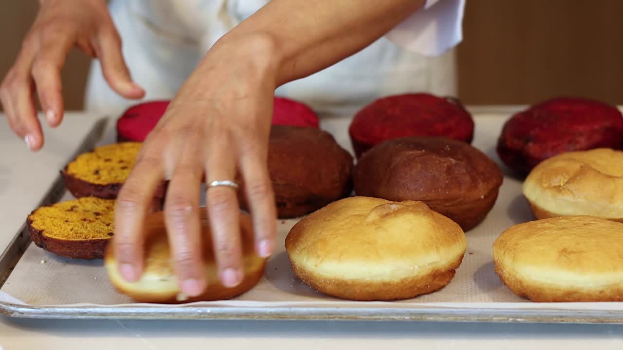 cocinero de cultivos poniendo pasteles de esponja en la bandeja en la cocina