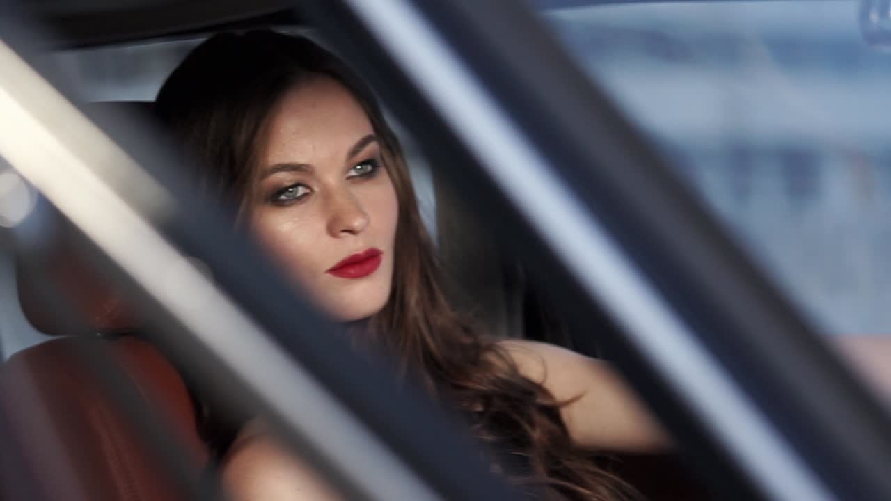 Woman in a Red Dress Inside a Car