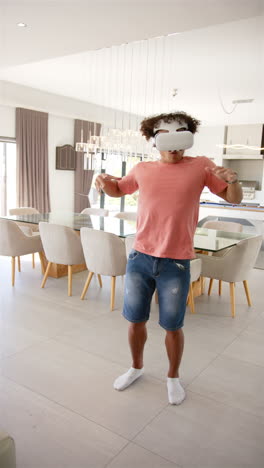 Vertical video: A young biracial male dances in his living room wearing VR headset