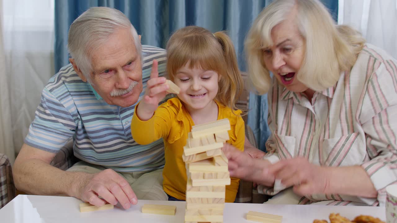 los abuelos y la nieta jugando al jenga.