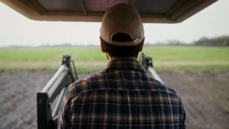 farmer driving tractor in field