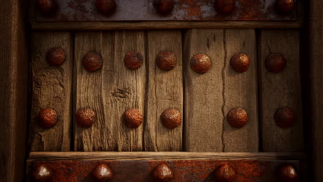 close-up of an old rustic wooden door with metal studs and iron accents