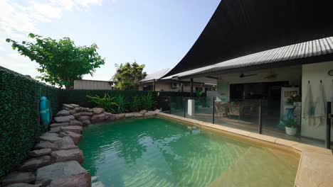 contemporary home with pool and modern design, perfect for upscale real estate listings, pullback over water and rock features into corner