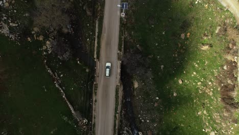 high aerial descending view above remote country road and white car, lebanon