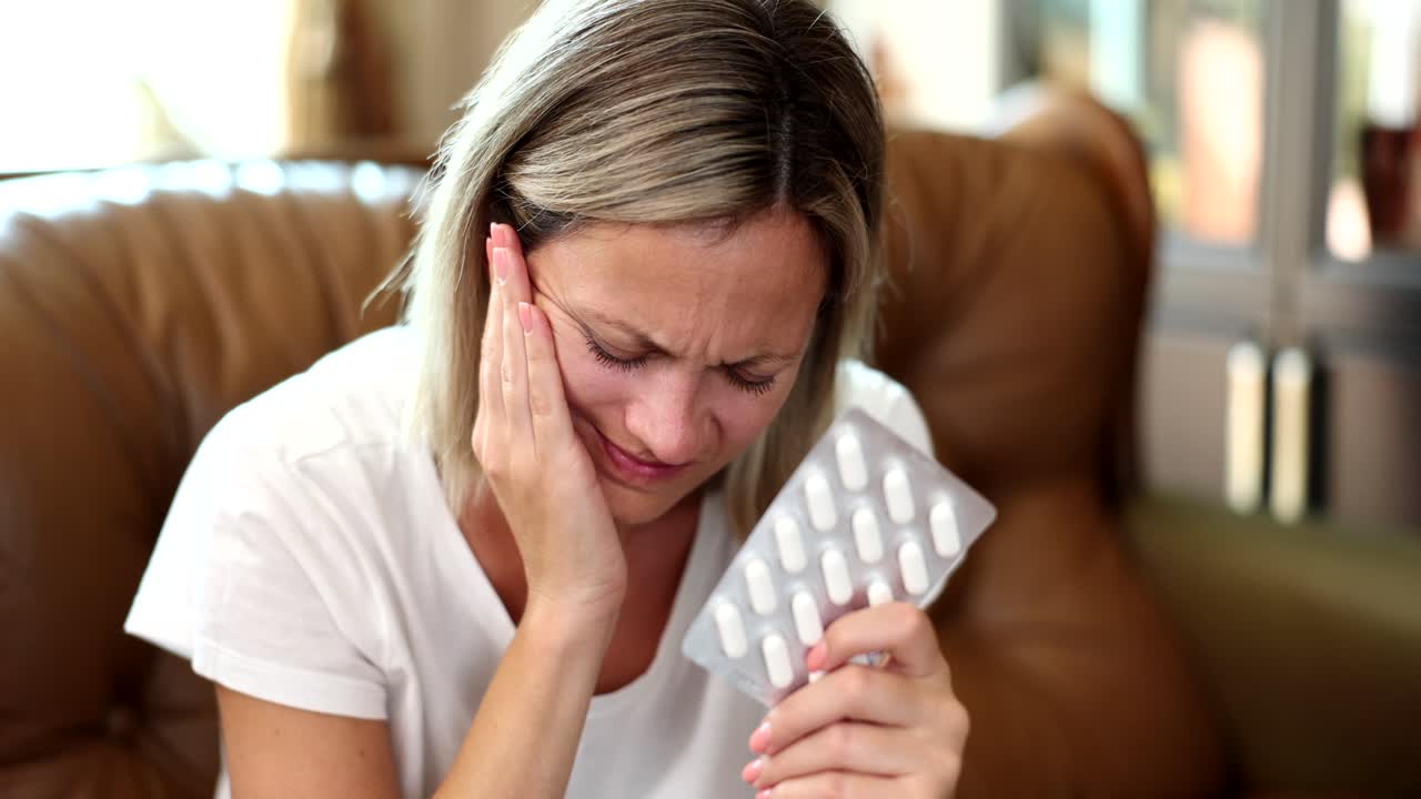 Woman with Toothache Holding Pills