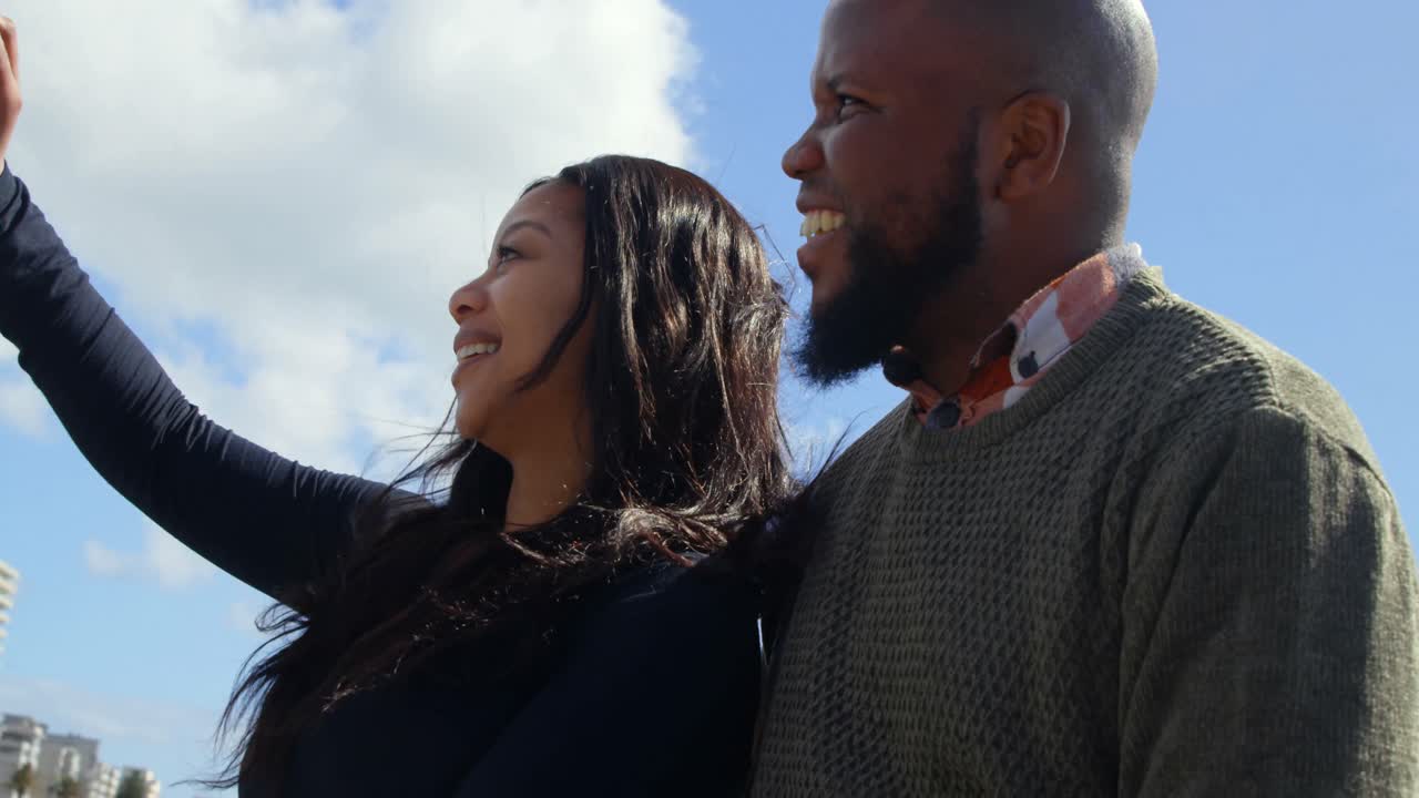 Couple taking selfie with mobile phone on sunny day 4k