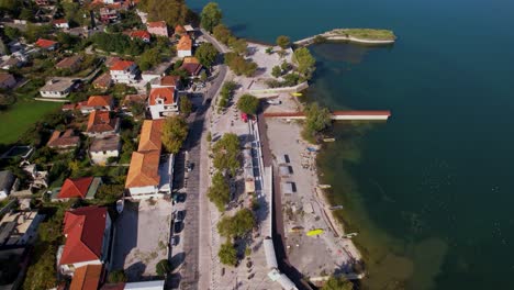 tourist village of shiroka in albania, with traditional houses and lakeside promenade