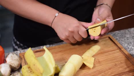 woman cutting plantain on a table wood