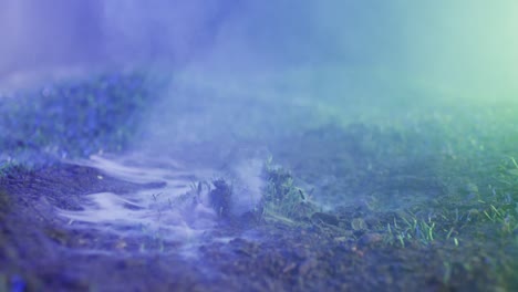 video of hand raising from grass with smoke on black background