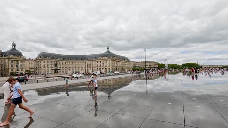 visitors interact with the reflective water surface