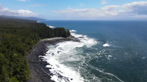 4k drone footage of straight forward flight over wild pacific coast line with big waves crashing down below