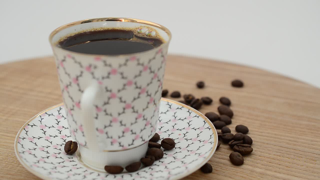 Ripresa in rotazione di caffè, tazza da caffè e chicchi. Girato in movimento.