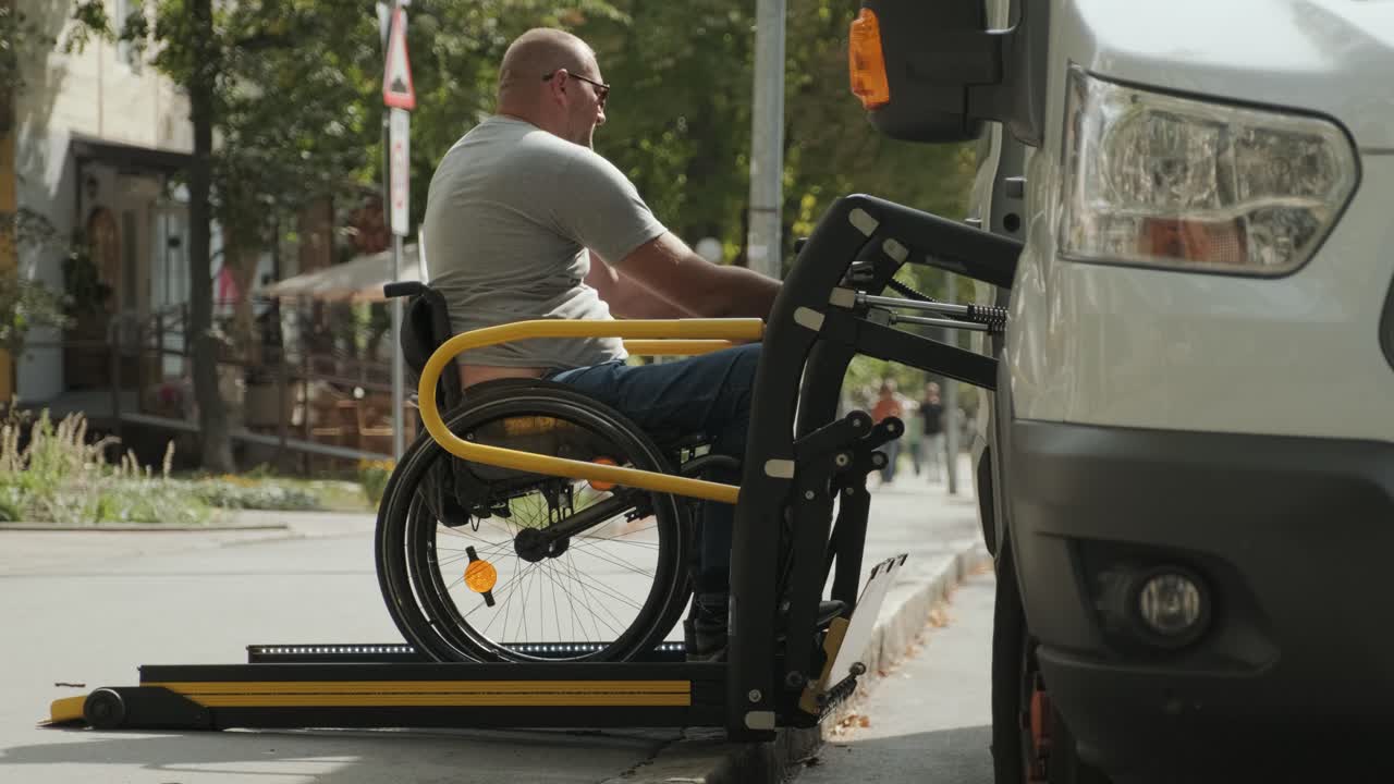 A man in a wheelchair on a lift of a vehicle for people with disabilities. Lifting equipment for people with disabilities - man in wheelchair near the vehicle