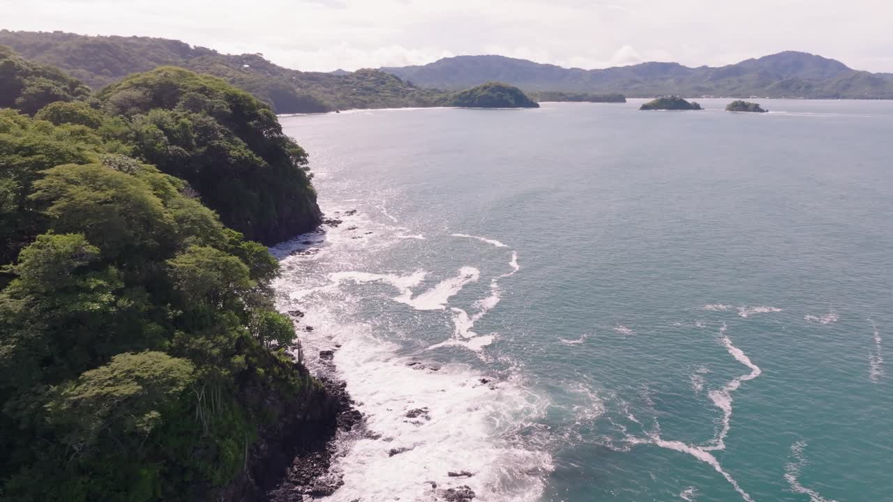 Las Catalinas, Guanacaste Province in Costa Rica showing homes, mountains and ocean with drone video spinning around