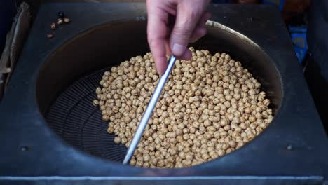 roasted chickpeas being tossed in a pan