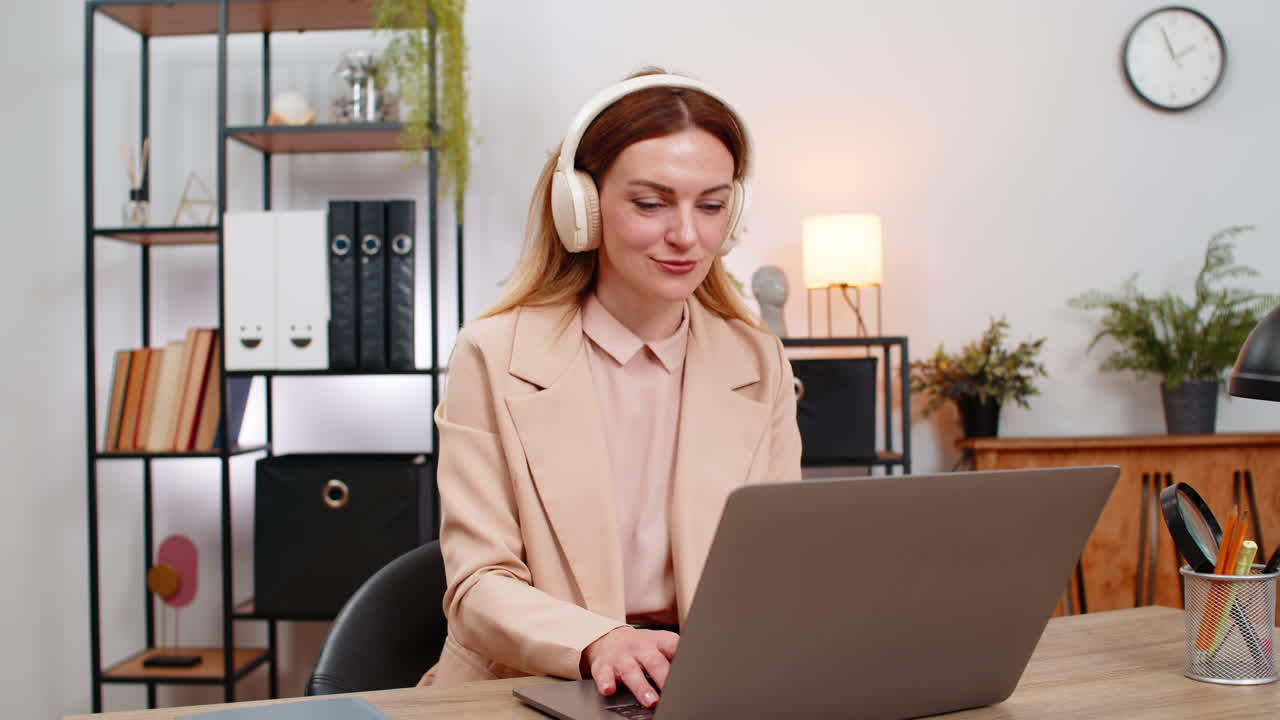 Forretningskvinde skriver rapport med høretelefoner på, rolig musik, fokus, rytme, nikker, fokuseret udseende, produktivt flow