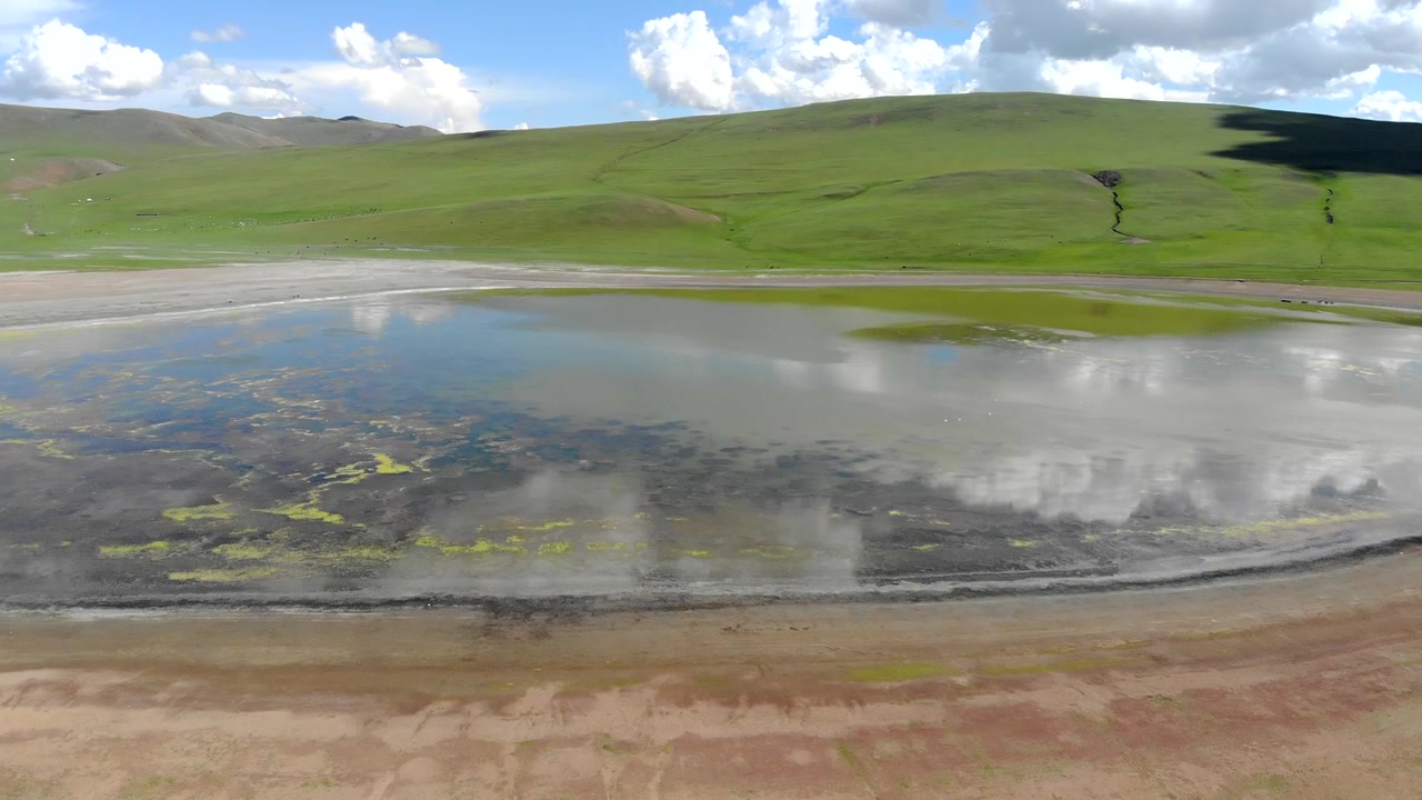 Aerial View of a Serene Mountain Lake in a Green Valley