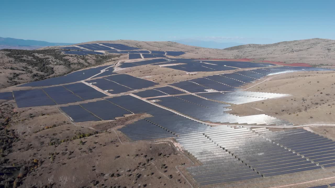 drones sobre enormes paneles de energía solar fotovoltaica en fila del parque día soleado cielo azul ancho