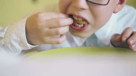 funny boy has dinner and delicious pizza at table closeup