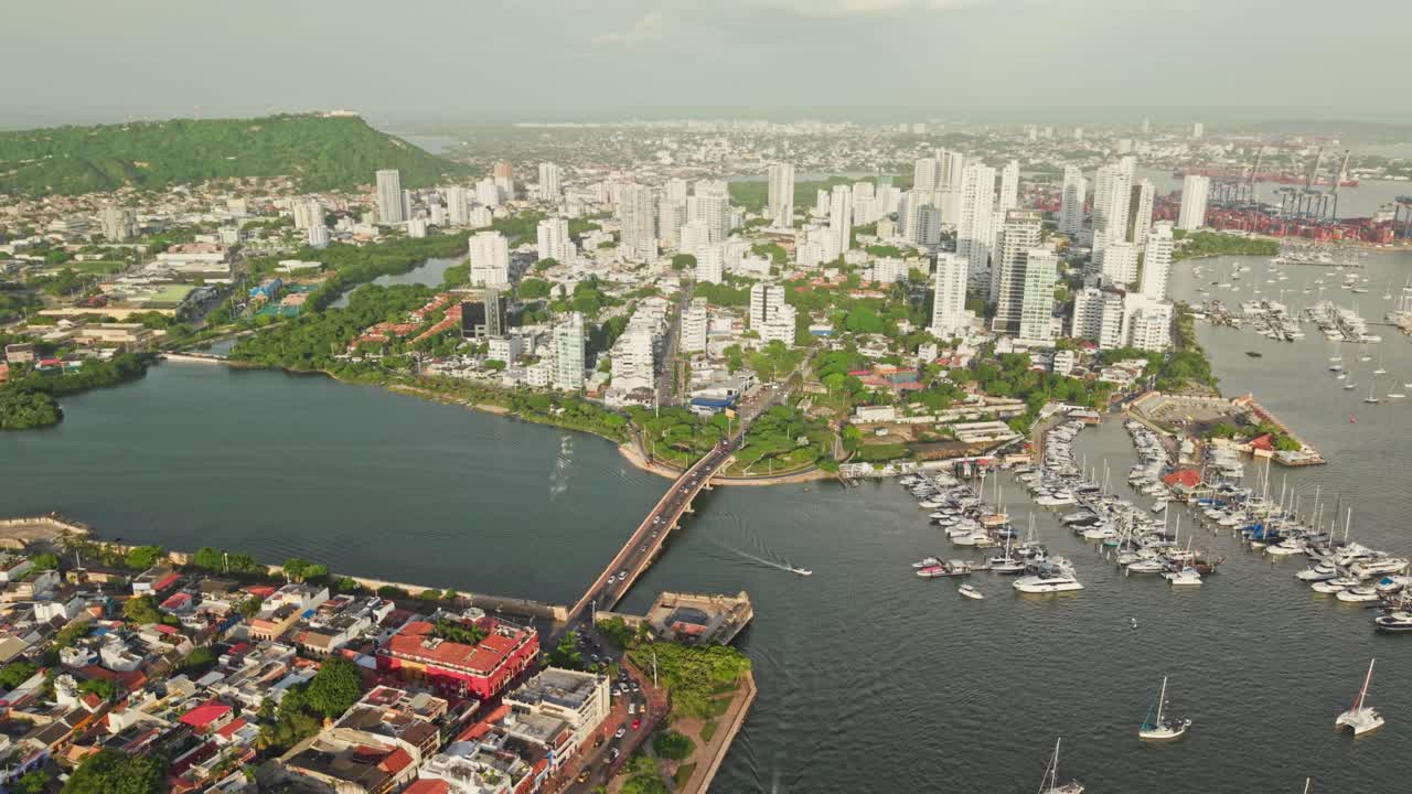 Vista aerea al rallentatore di Cartagena, Colombia, con il quartiere Manga, un ponte, barche e il paesaggio urbano