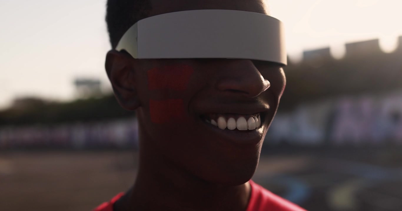 Young Black Man Wearing Futuristic Visor Changes Expression to a Smile