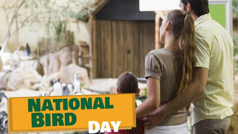 animation of national bird day text in green over parents and daughter watching penguins at zoo