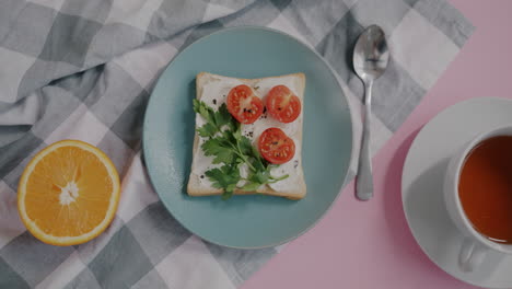 simple breakfast with toast, cream cheese, tomatoes, parsley and tea