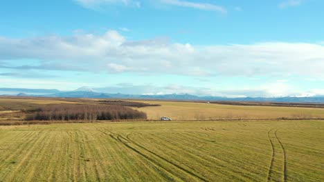 Luftrückzug-Folgen-Sie-Dem-Auto,-Das-Auf-Der-Landstraße-Auf-Islandfeldern-Fährt