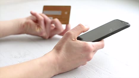 woman-paying-for-online-shopping-by-her-credit-card-and-phone-in-hand-stock-video-stock-footage