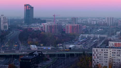 sunset over a modern city with train station and highway