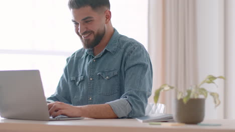 hombre trabajando en una computadora portátil en casa