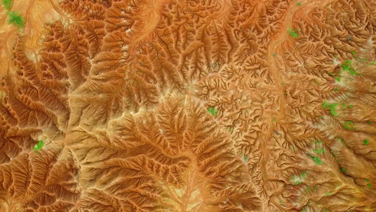 maravillarse del paisaje surrealista pintado con tonos de carmesí y ocre mientras el sol arroja sus rayos dorados sobre el terreno accidentado