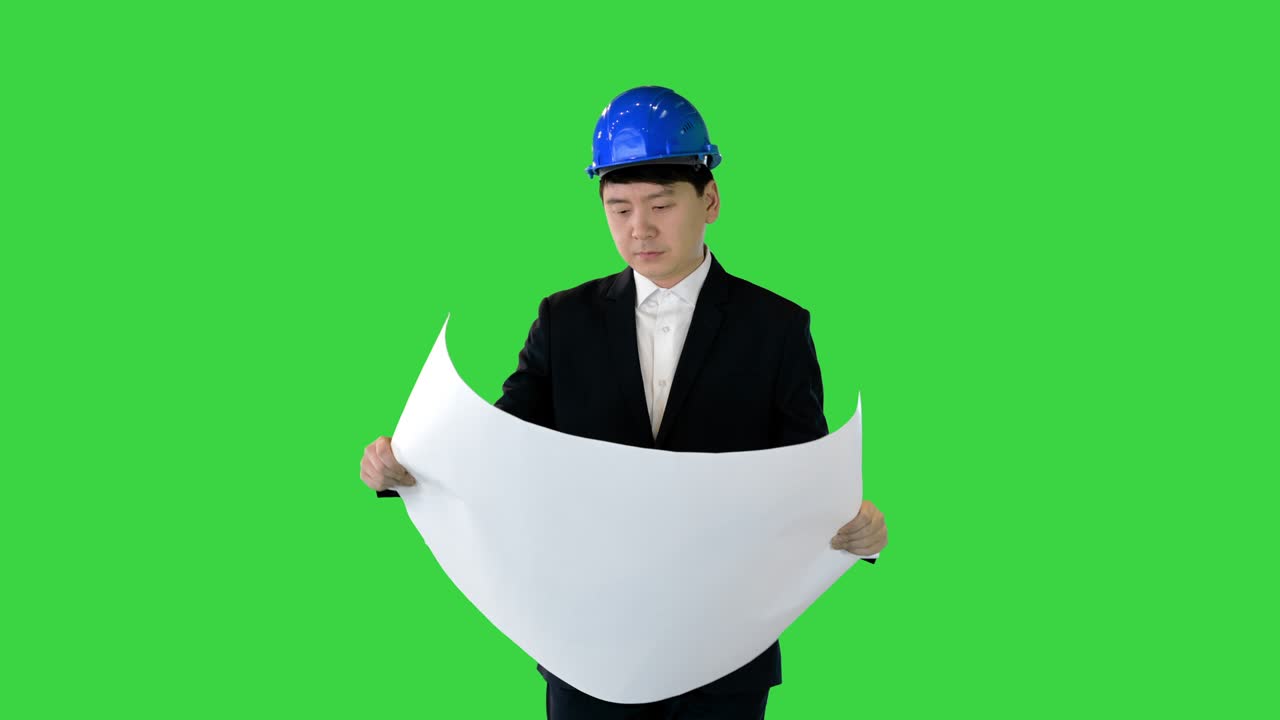 Architect looking at blueprint while walking and looking around on a Green Screen, Chroma Key