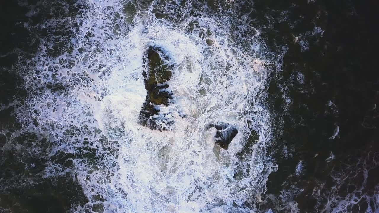 Waves crash against the rocks. An iconic place on the Atlantic coast, the Mecca of surfing on big waves.Rocks at the Nazare Lighthouse, the place with the largest waves in Europe, Nazare, Portugal