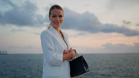 lady boss standing sunset sky looking camera close up. woman posing at seascape