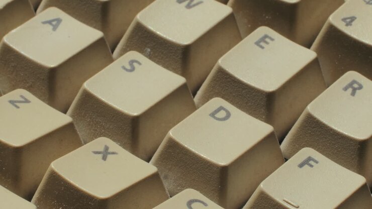 Uomo che lavora e gioca su un computer PC retrò, ingegnere informatico con computer vintage a casa, che usa tecnologia vecchio stile, primo piano di una configurazione retrò.