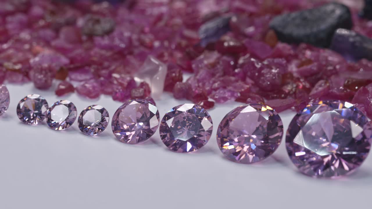 diamantes de ametista en una fila sobre fondo de piedra preciosa de rubí crudo de flor blanca.