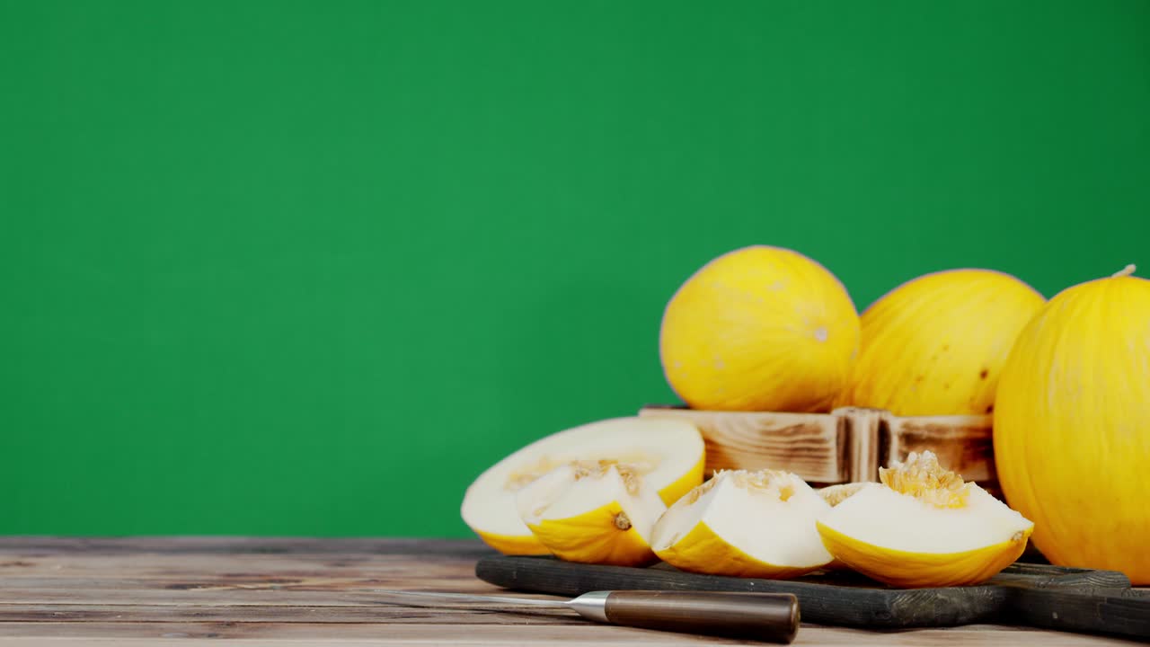 Male hand puts the knife on the table near to sliced melon.