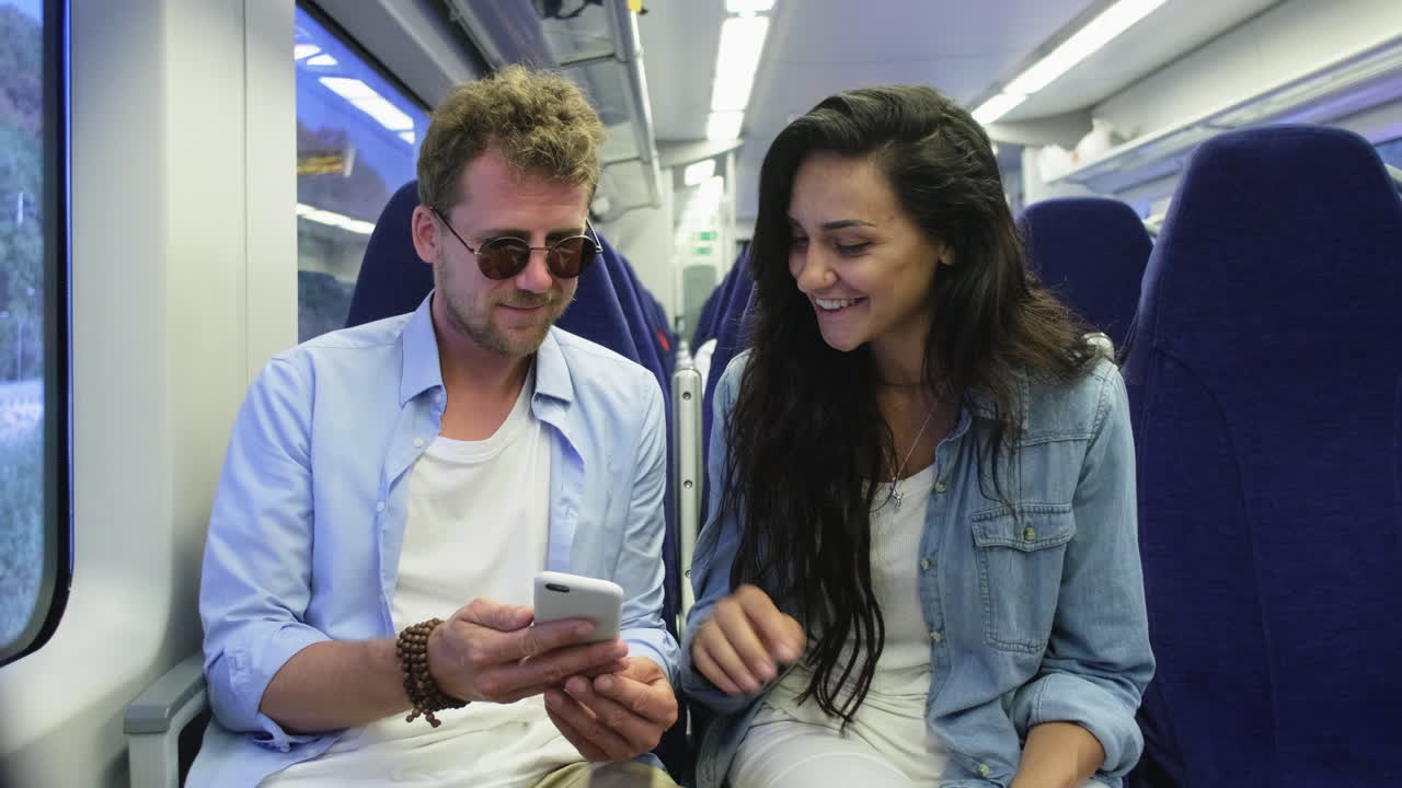 una pareja usando un teléfono inteligente en un tren