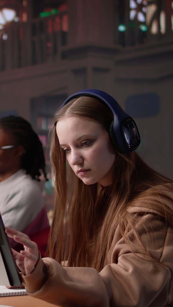 Vertical video young female adult listening to therapy music and working on her bachelor paper