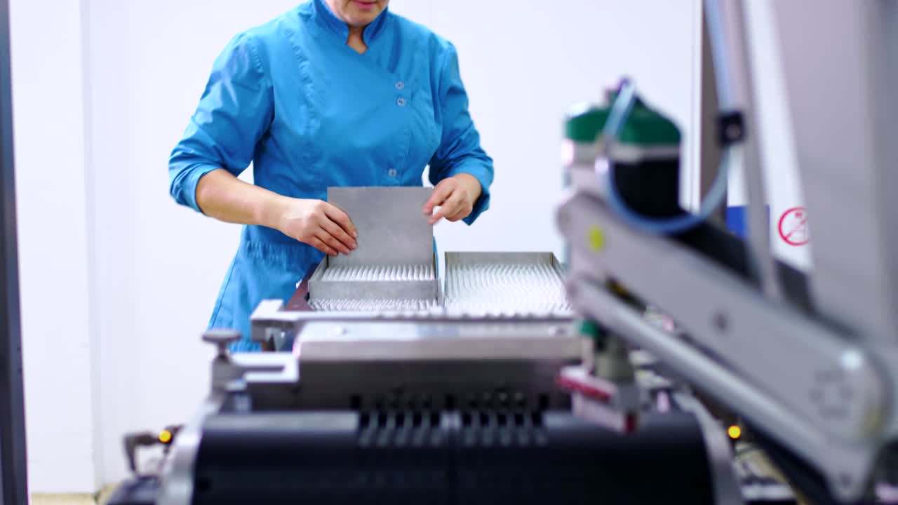 의약품 포장 기계에 의약품 병을 로딩하는 의약품 노동자