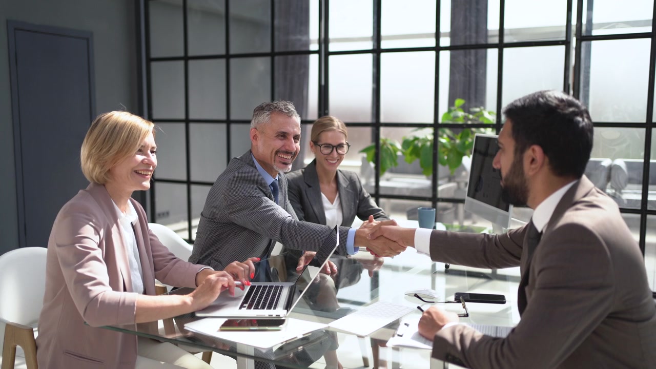 Profesionales de negocios estrechando manos durante una reunión en una oficina moderna